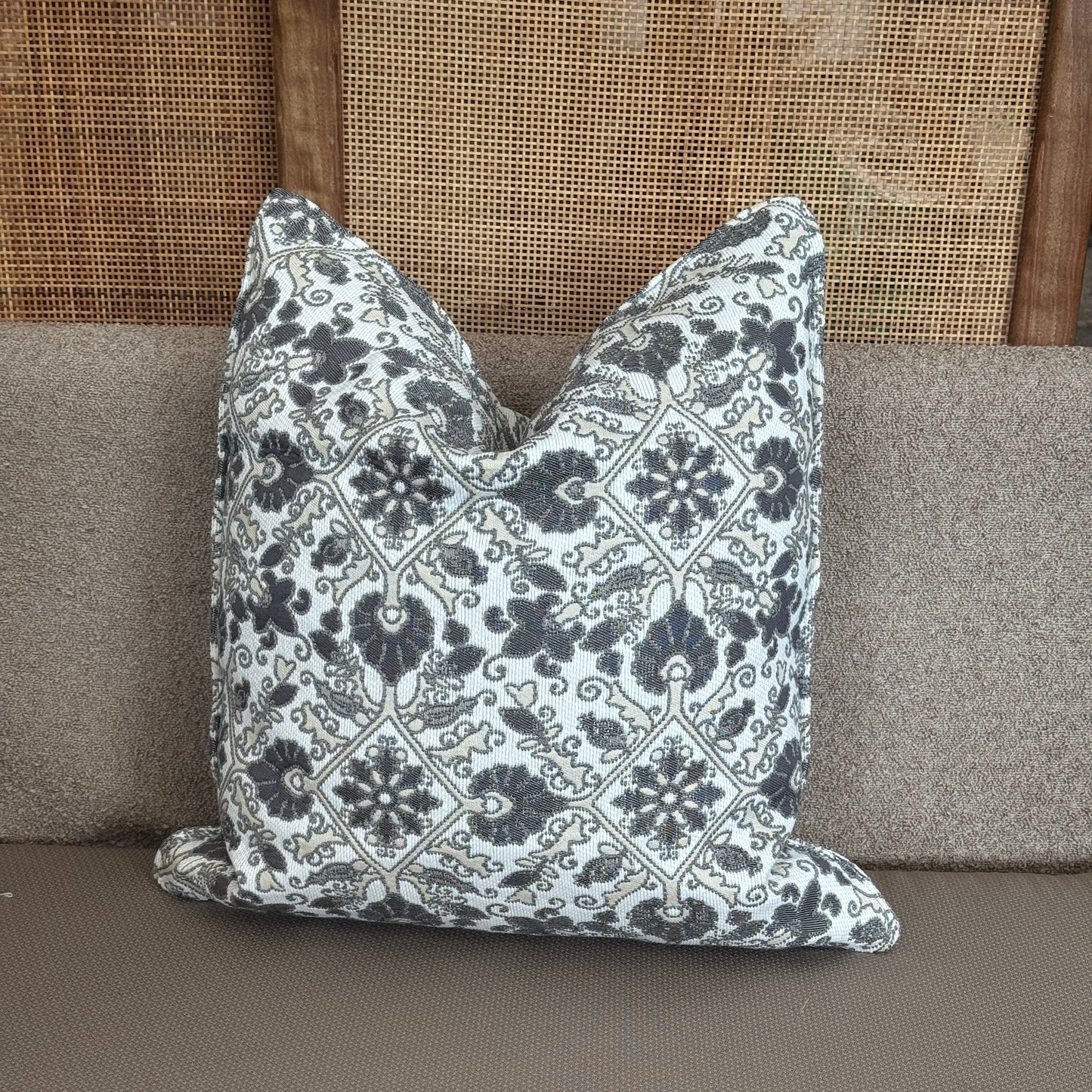 Coussin décoratif à motifs arabesques noirs et blancs sur fond clair, apportant une touche élégante et intemporelle à la décoration intérieure.