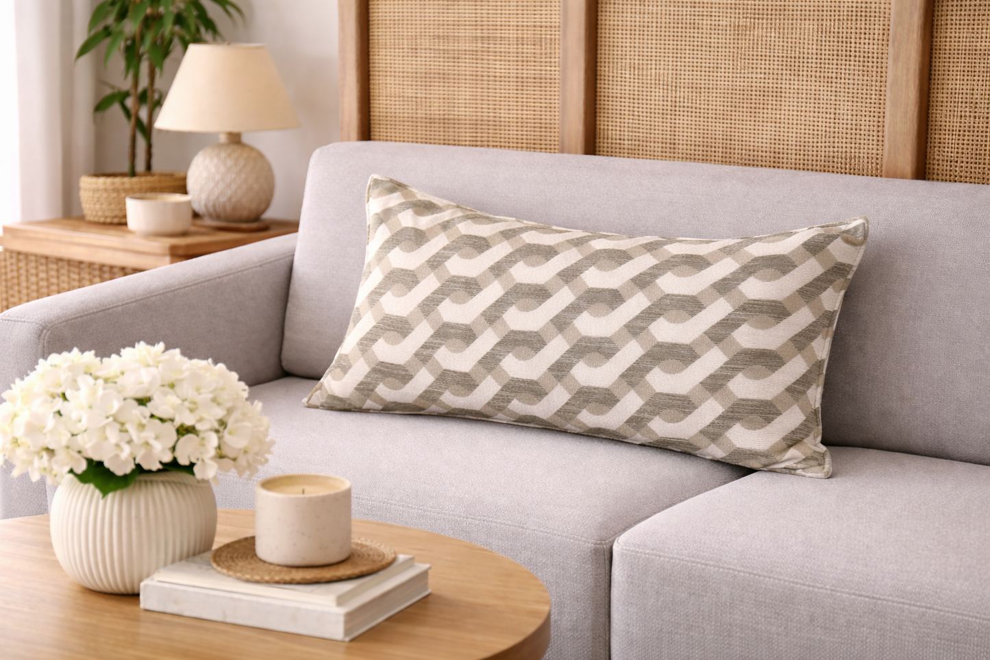 Coussin rectangulaire à motif géométrique vert et écru mis en scène dans un salon lumineux au style moderne et élégant