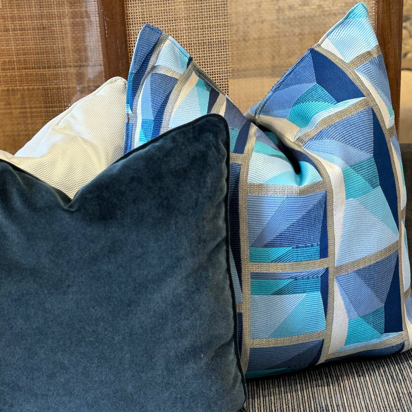 Coussin décoratif en tissu tissé à motif graphique géométrique, teintes bleues et gris .