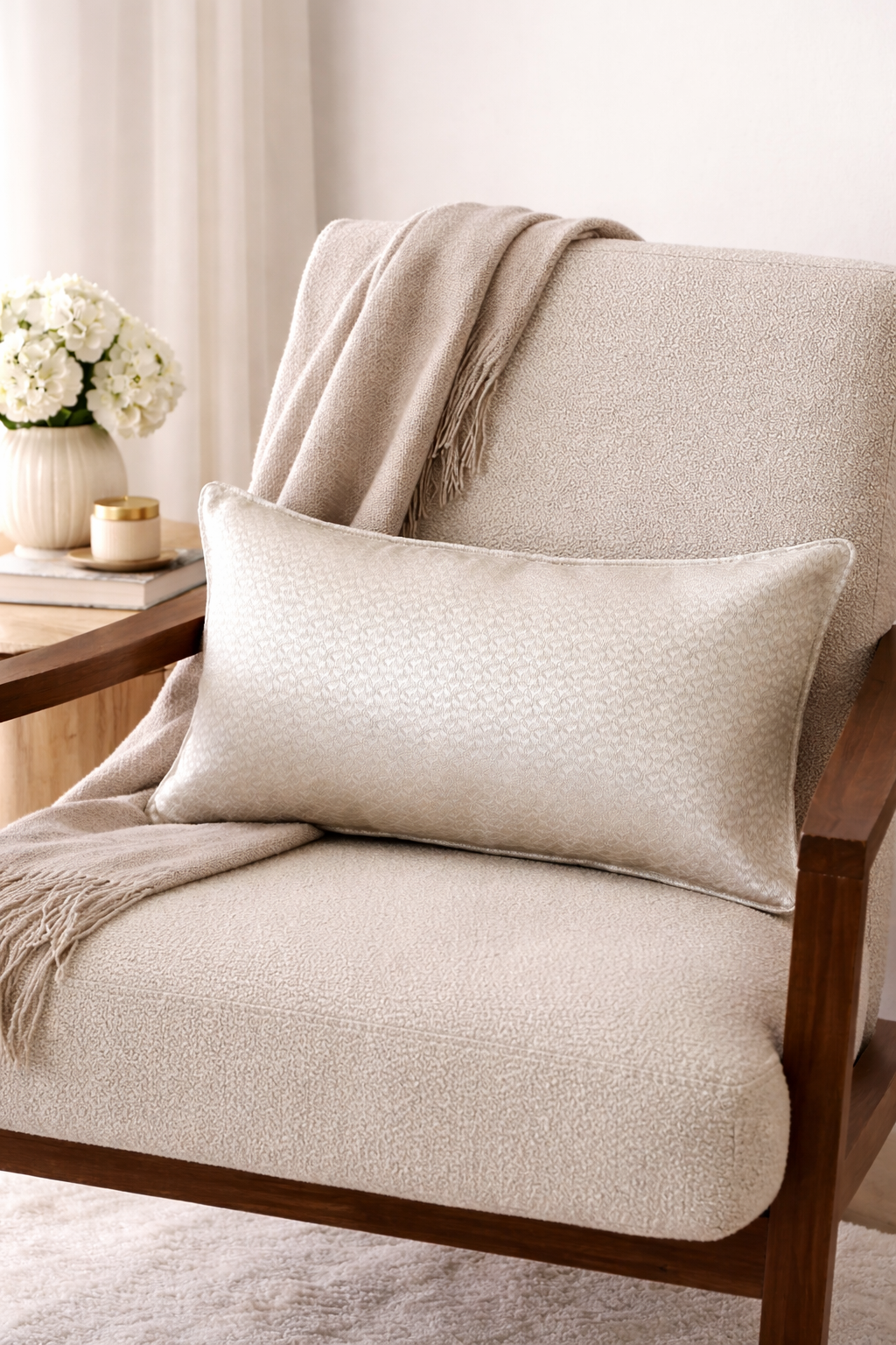 Coussin rectangulaire écru à motif discret posé sur un fauteuil dans une ambiance moderne et élégante