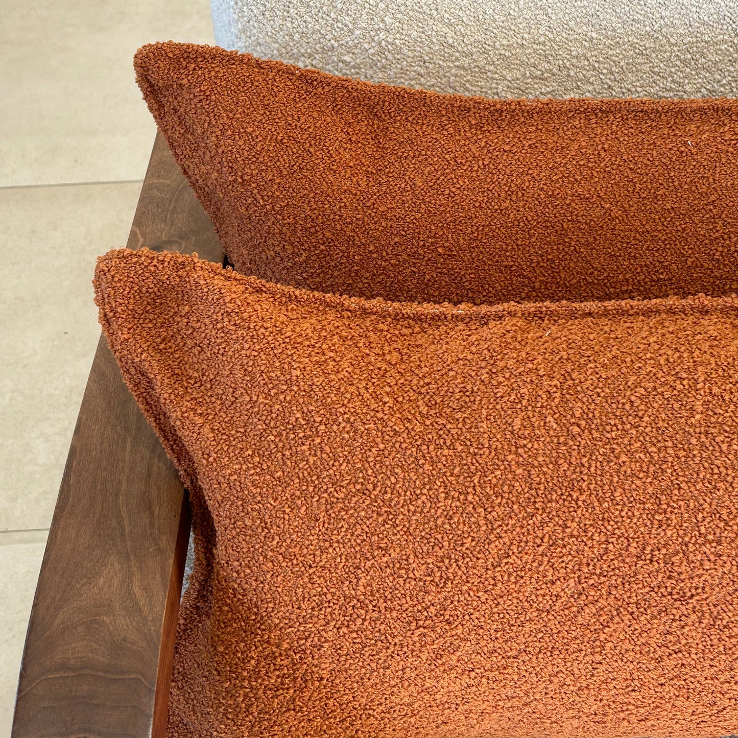 Détail de la texture bouclette terracotta d’un coussin décoratif rectangulaire