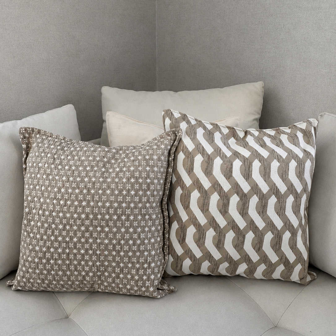 Duo de coussins décoratifs beige et écru en tissu marocain texturé, présenté sur un canapé clair dans une ambiance moderne et minimaliste – Biyadi Collection.