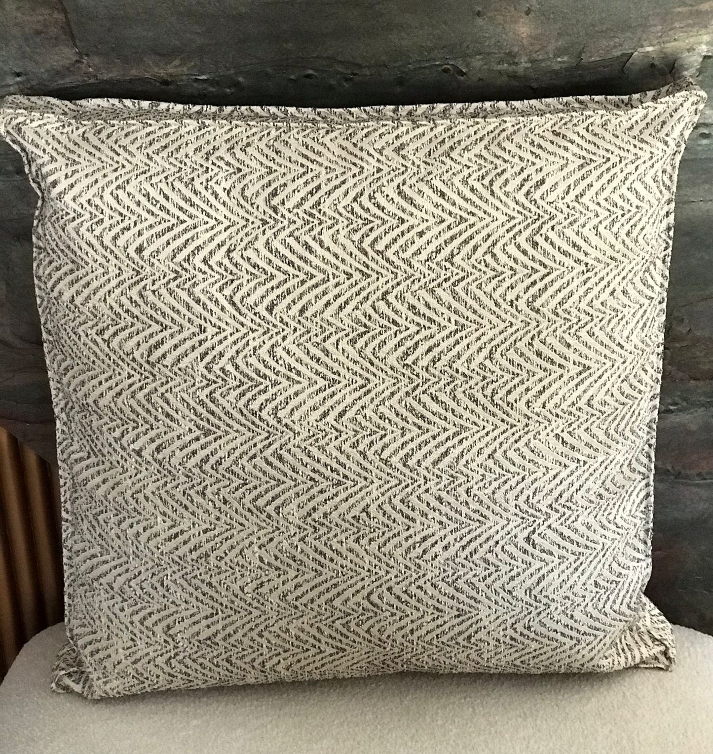 Coussin décoratif gris à motif chevron texturé, style moderne et élégant pour salon contemporain.