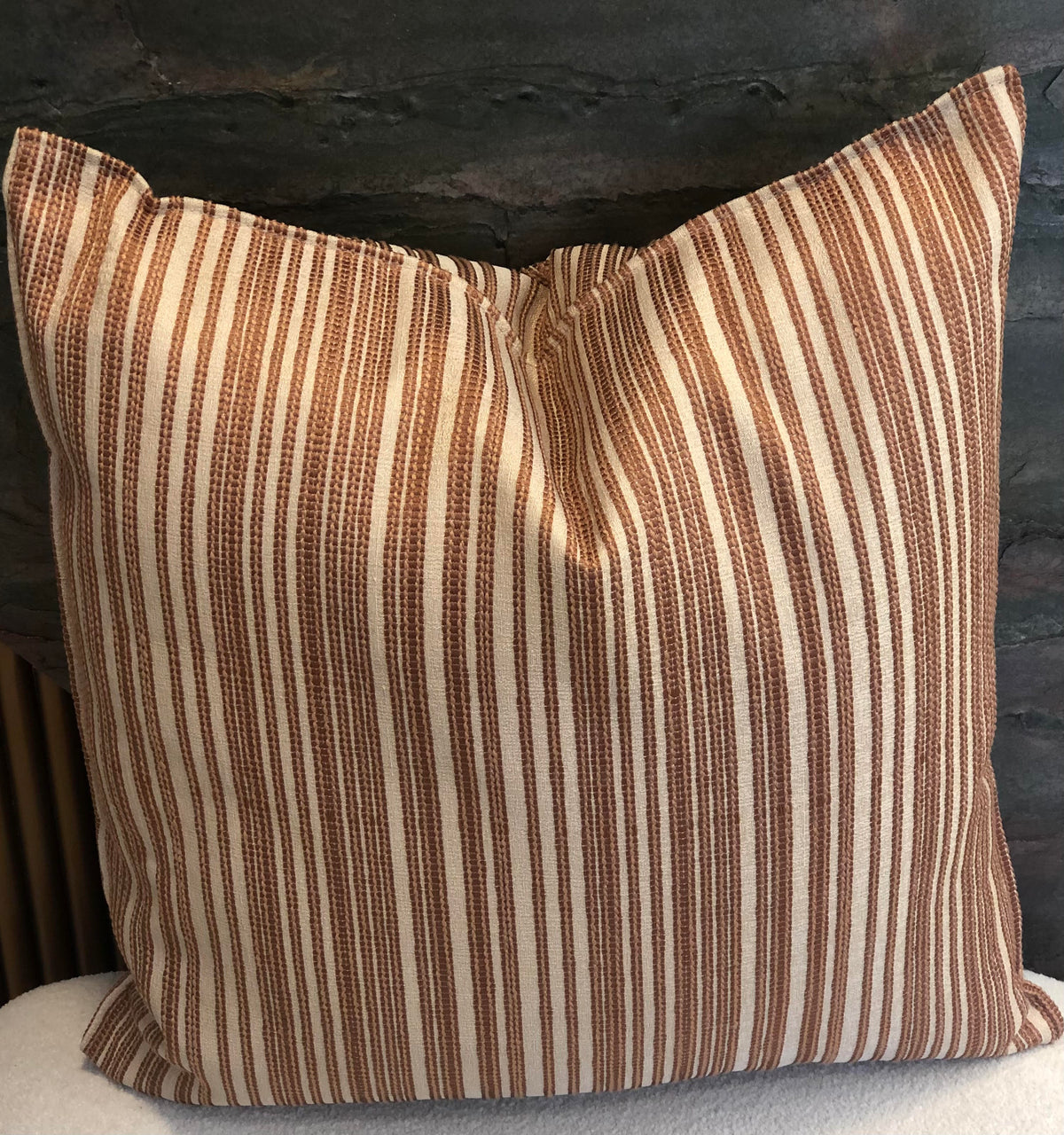 Coussin décoratif 50x50 cm à rayures verticales ocre et écru en tissu texturé.