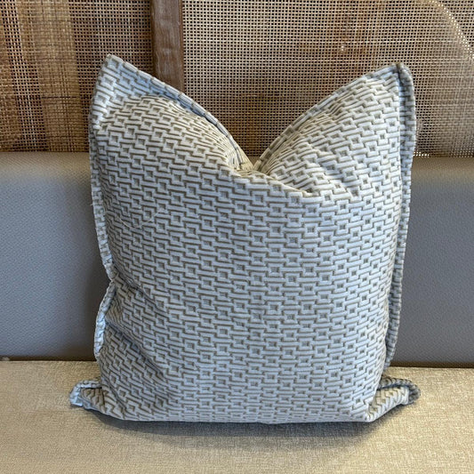 Coussin décoratif uni ivoire en tissu texturé, tissage en relief et finition haut de gamme.