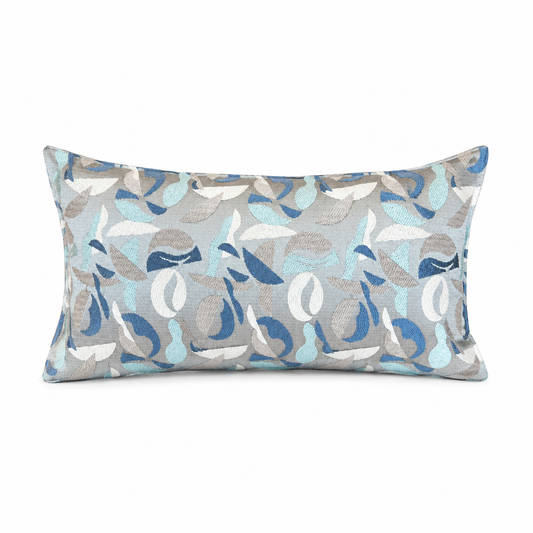 Coussin rectangulaire décoratif bleu et gris clair avec motif abstrait bleu, beige et écru, style moderne et élégant pour salon contemporain.