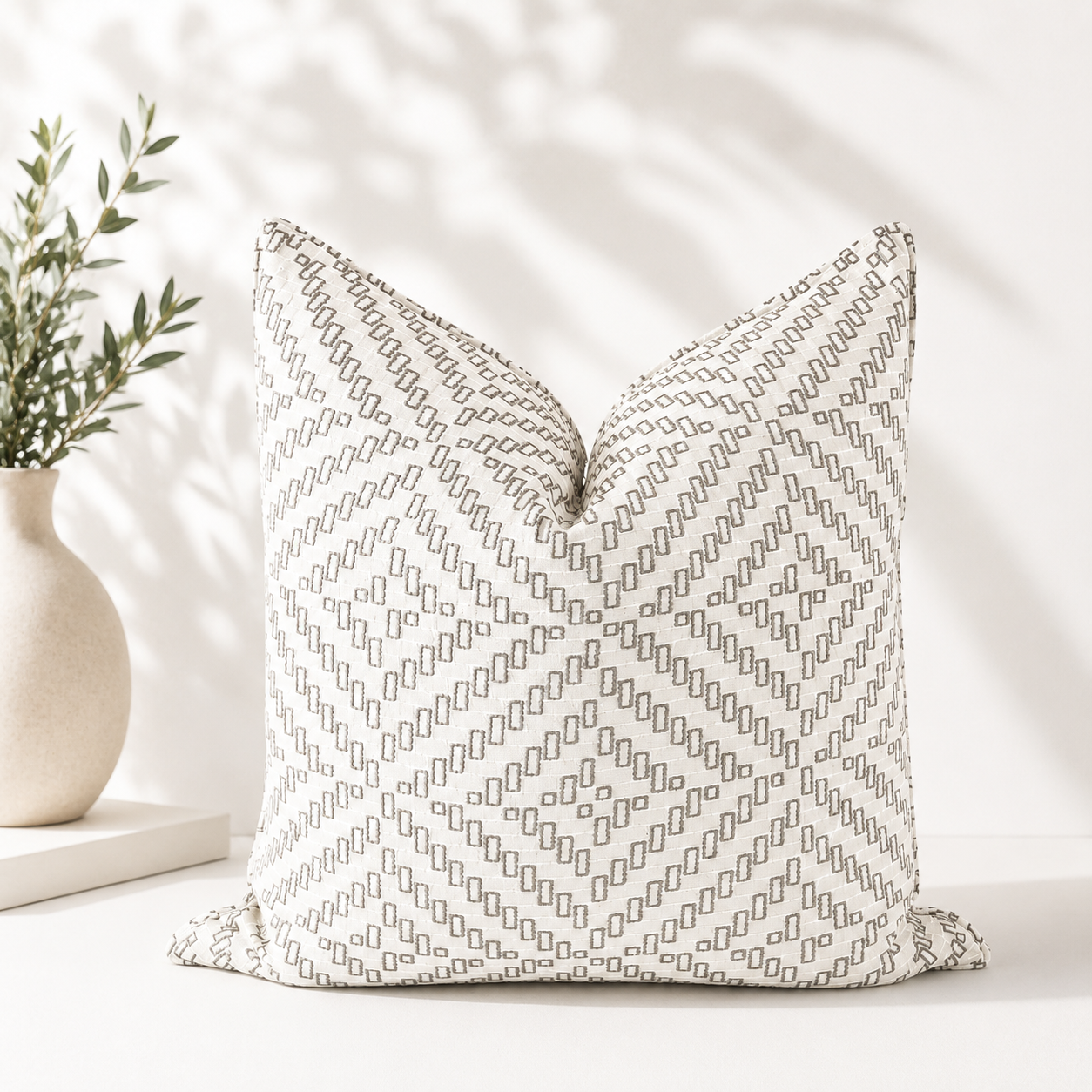 Coussin carré écru à motif géométrique beige en tissu tissé au Maroc.