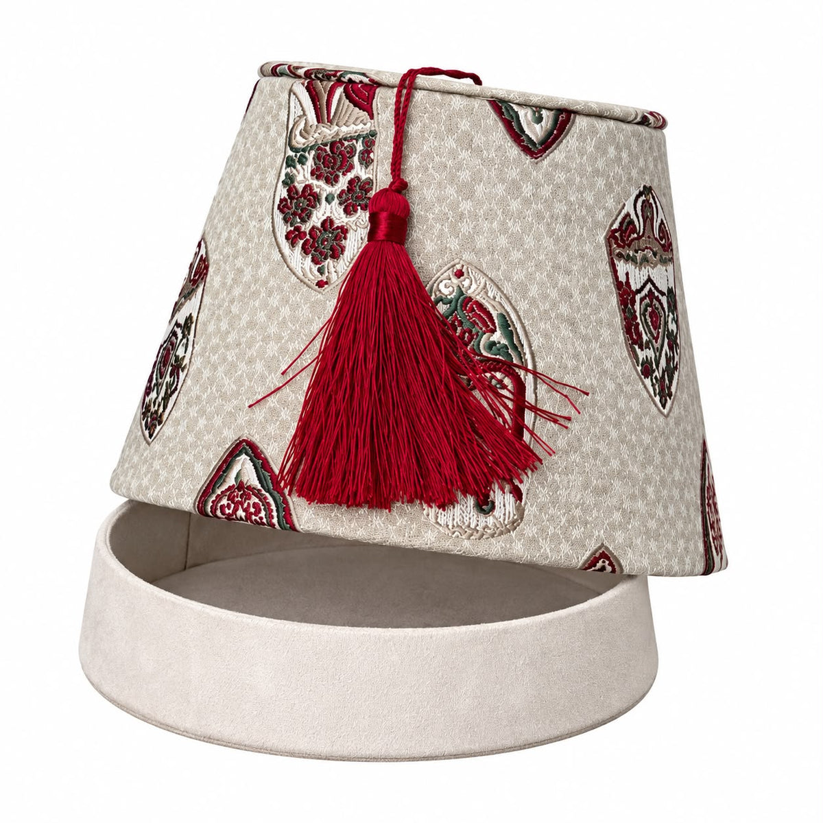 Boîte décorative Tarbouche Biyadi Collection en tissu marocain beige à motifs rouges et verts, avec pompon rouge, présentée ouverte au-dessus de son socle de rangement beige sur fond blanc.