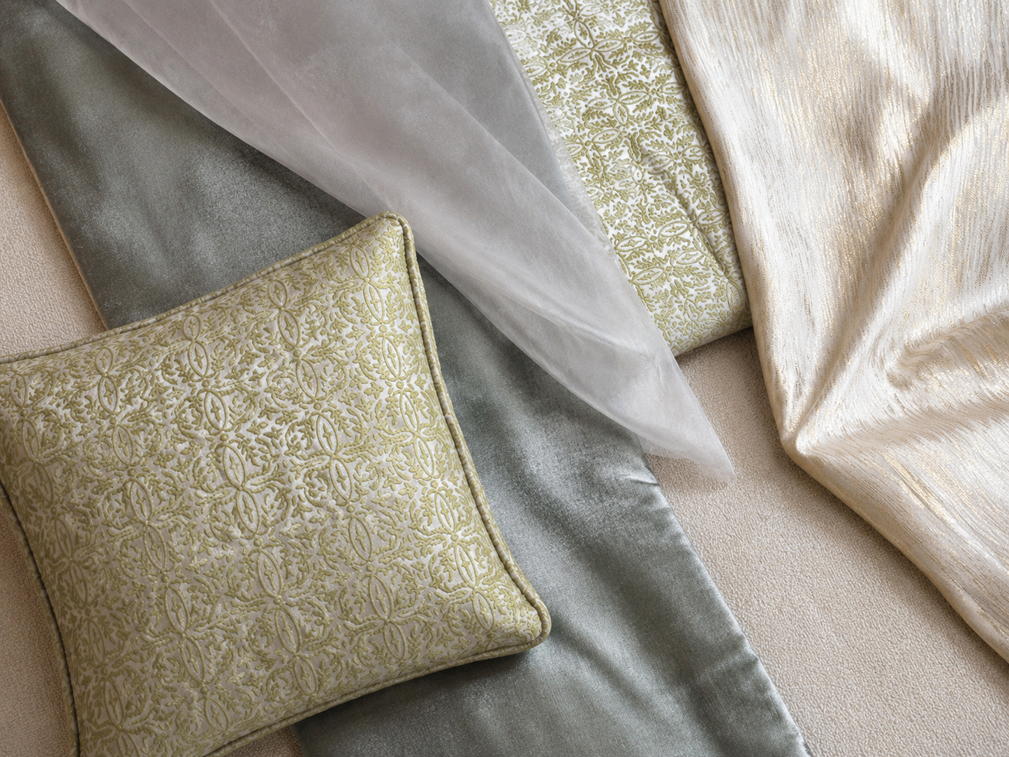 Composition de tissus d’ameublement haut de gamme mêlant vert , champagne et écru, accompagnée d’un coussin décoratif à motif oriental tissé en relief. Une harmonie douce et sophistiquée idéale pour un salon marocain moderne.