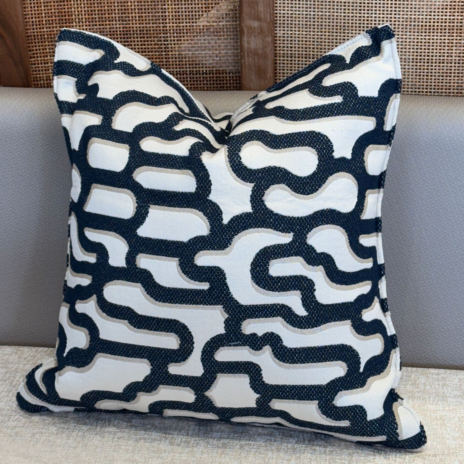 Coussin décoratif abstrait bleu et ecru en tissu marocain tissé en relief avec motif graphique moderne – Biyadi Collection.