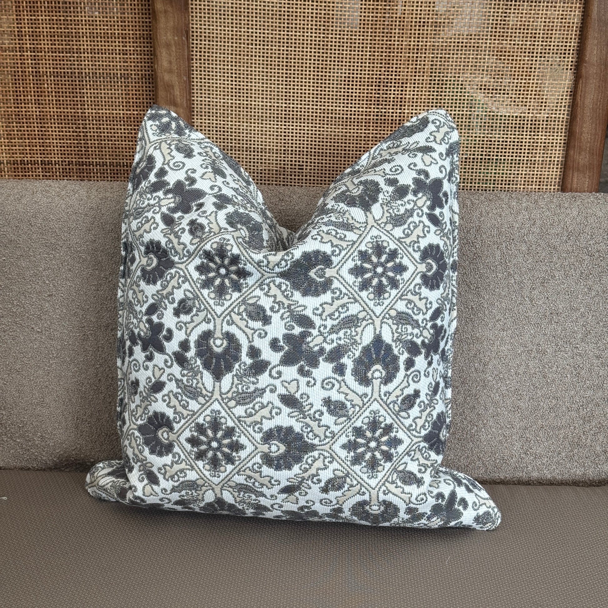 Coussin décoratif à motifs arabesques noirs et blancs sur fond clair, apportant une touche élégante et intemporelle à la décoration intérieure.