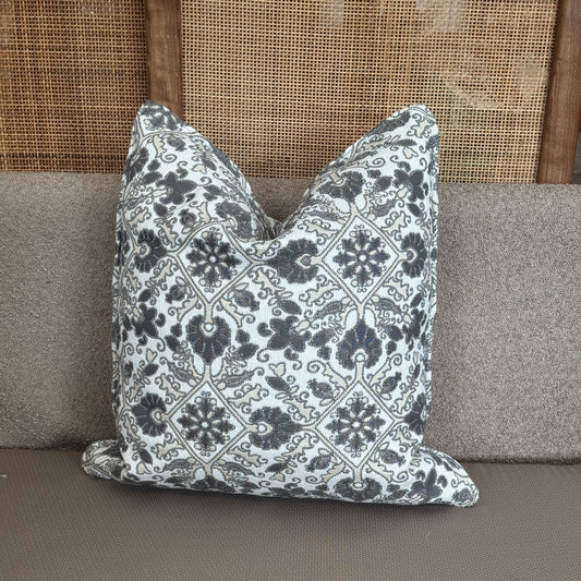 Coussin décoratif à motifs arabesques noirs et blancs sur fond clair, apportant une touche élégante et intemporelle à la décoration intérieure.
