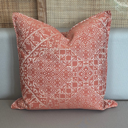 Coussin  effet brodé terracotta à motifs géométriques blancs .
 
