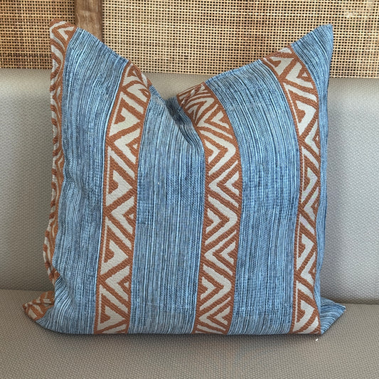 Coussin décoratif bleu et brun à bandes verticales et motifs géométriques ethniques, apportant une touche bohème et chaleureuse à la décoration intérieure