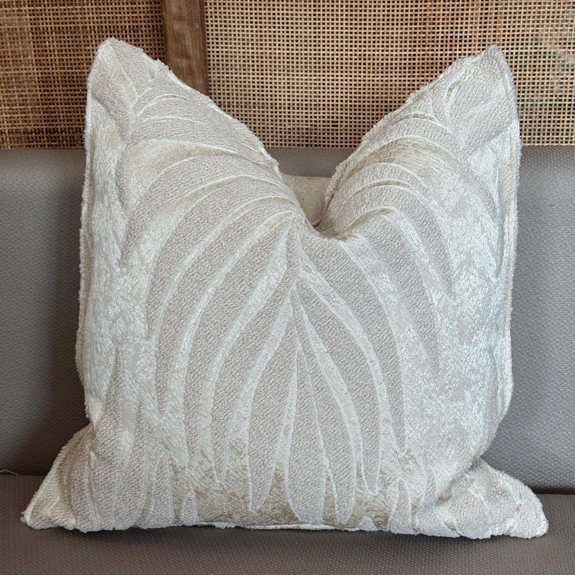Coussin décoratif bouclette ivoire avec motifs en relief de feuilles élégantes, apportant douceur et raffinement à la décoration intérieure.