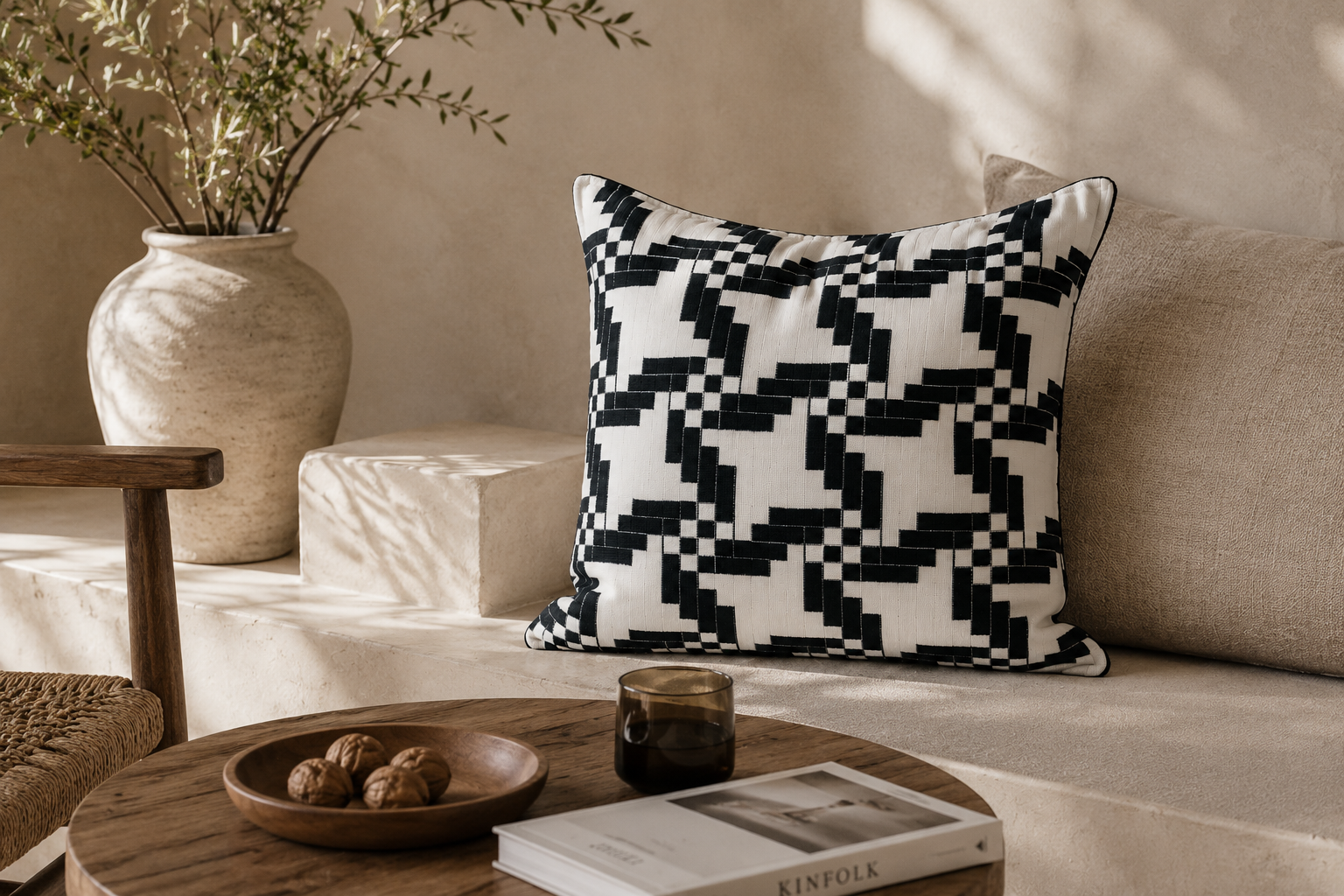 Composition de coussins noir et blanc en tissu marocain tissé en relief dans une ambiance salon moderne et minimaliste – Création exclusive Biyadi Collection.