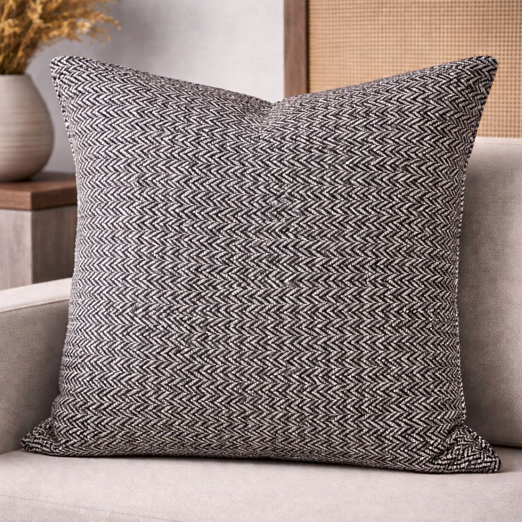Coussin décoratif noir et blanc à motif chevron, tissé en relief, posé sur un canapé clair – Biyadi Collection