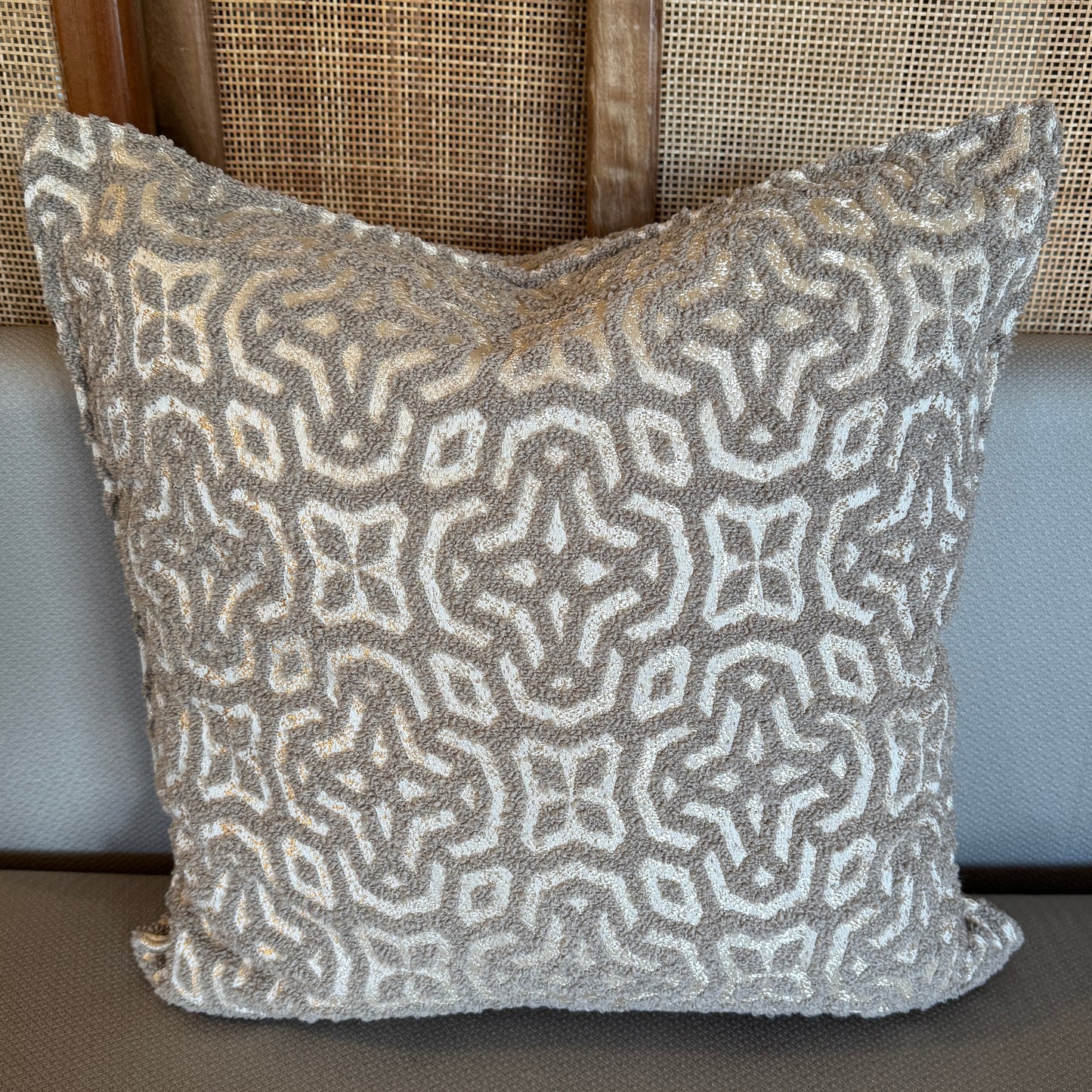 Coussin décoratif en tissu texturé à motif géométrique, teinte taupe.
