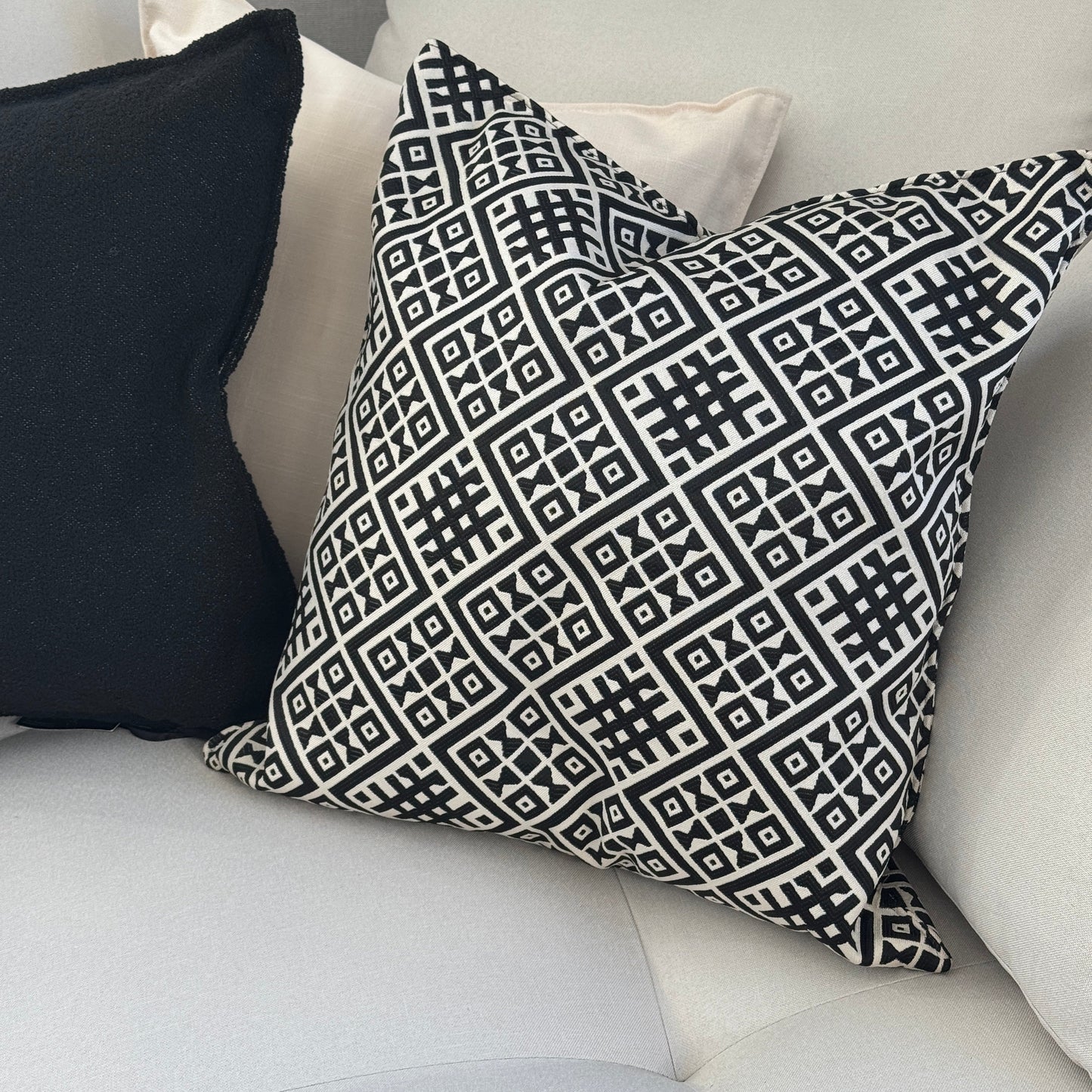 Coussin ethnique noir et blanc à motif géométrique marocain, tissu tissé en relief, posé sur canapé moderne – Biyadi Collection