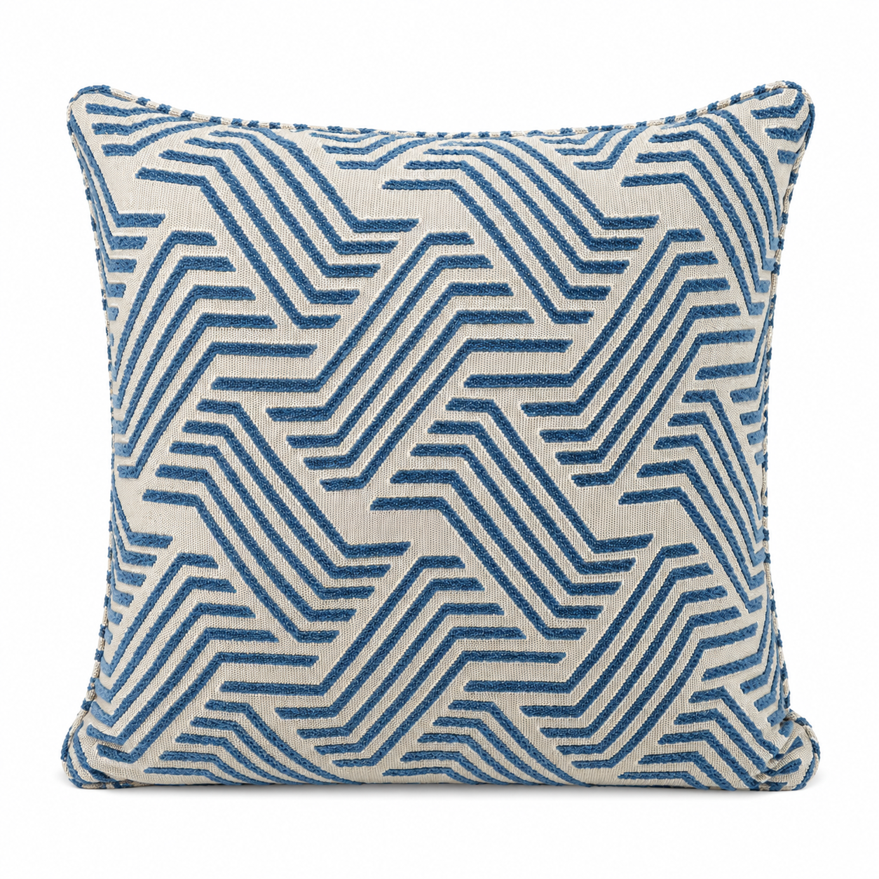 Coussin décoratif bleu et écru à motif graphique géométrique en relief sur fond blanc, style moderne et élégant pour décoration intérieure.