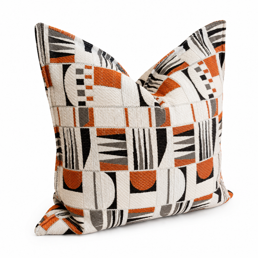 Coussin décoratif graphique terracotta et écru posé sur canapé beige dans un salon contemporain