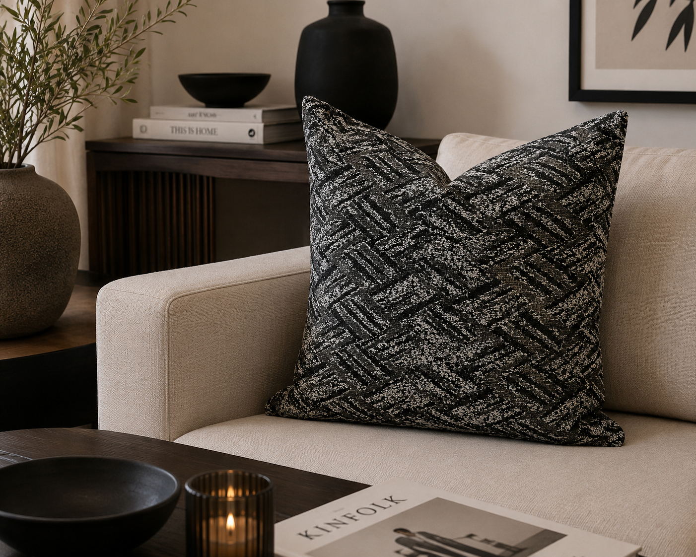 Coussin bouclette noir et blanc  à texture géométrique dans un salon moderne et élégant avec canapé beige et décoration minimaliste haut de gamme.