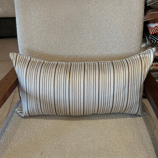 Détail d’un coussin rectangulaire à rayures taupe et écru, tissu texturé avec léger effet lumineux