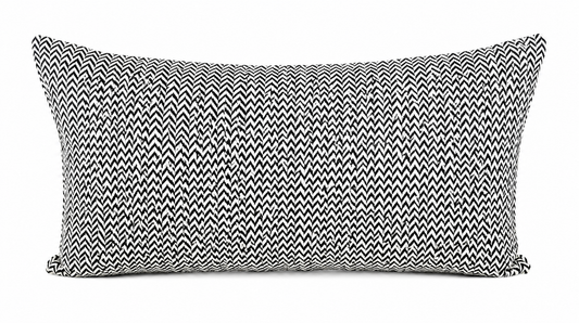 Coussin rectangulaire noir et blanc à motif chevron graphique, style moderne et minimaliste avec tissu texturé pour décoration élégante de salon.