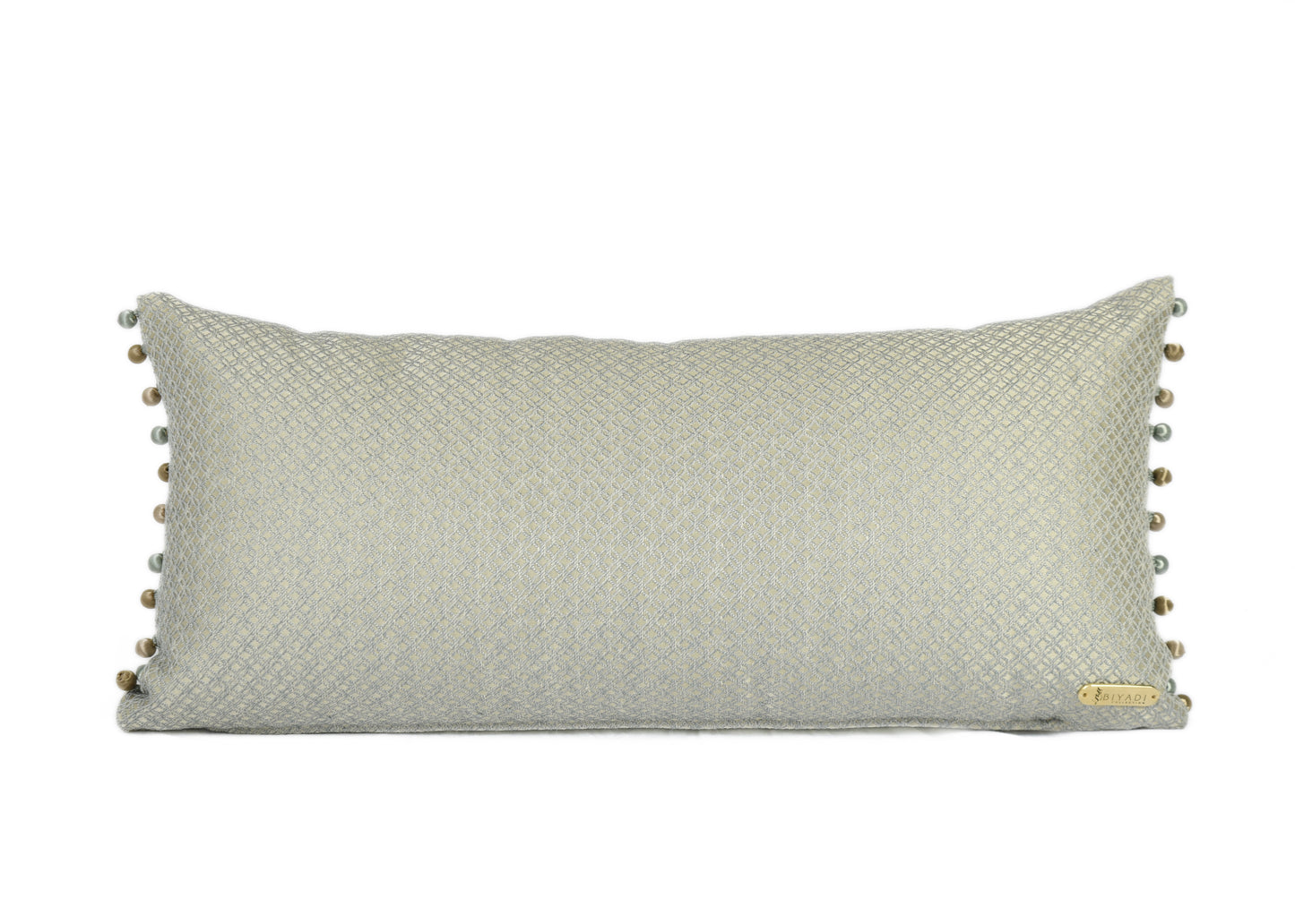 Coussin décoratif rectangulaire bleu et doré avec finition en perles, confectionné en tissu d'ameublement tissé au Maroc.