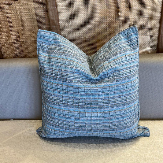 Coussin décoratif en tissu texturé bleu azur, tissage en relief et finition élégante.