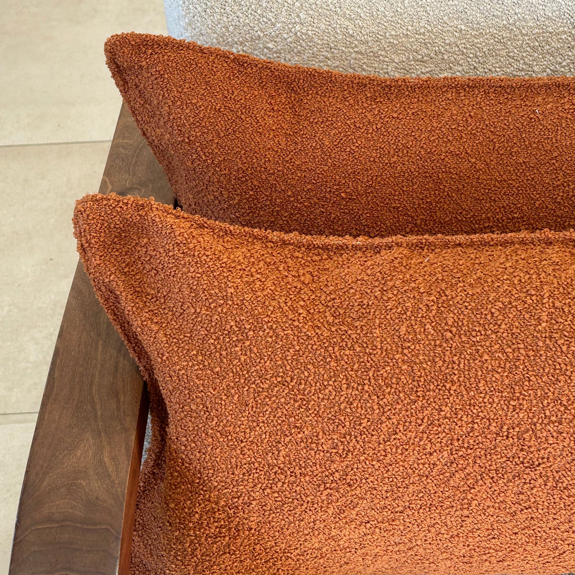 Détail de la texture bouclette terracotta d’un coussin décoratif rectangulaire