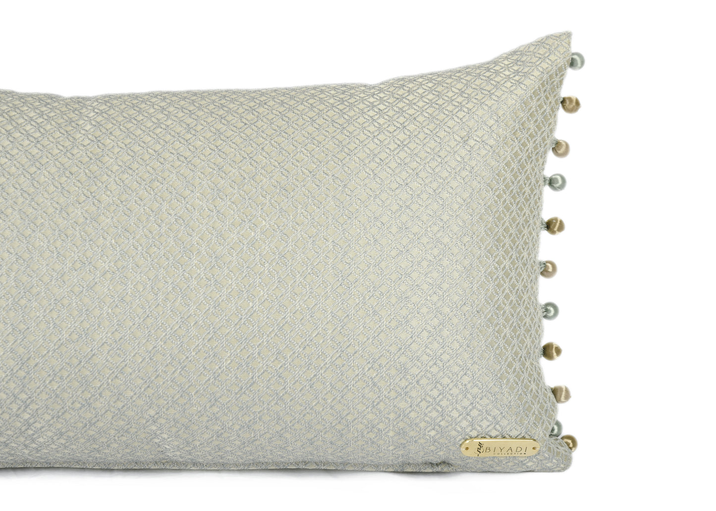 Détail du coussin décoratif rectangulaire bleu et doré avec finition en perles, confectionné en tissu d'ameublement tissé au Maroc.