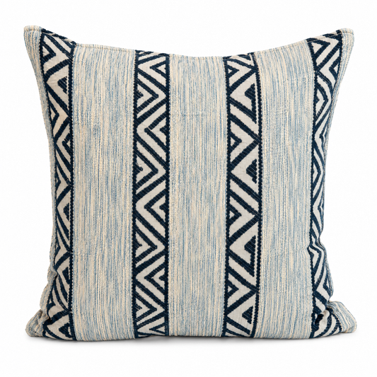 Coussin décoratif en tissu tissé à bandes verticales bleu clair et motifs zigzag bleu foncé, au style graphique et contemporain.