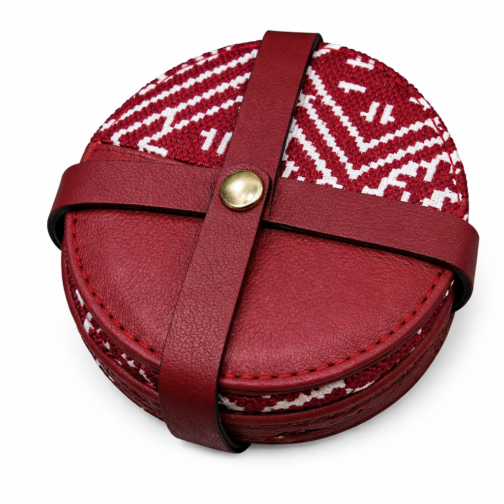 Pack de sous-tasses rondes bordeaux en cuir et tissu Tarz à motifs écrus, maintenu par une attache en cuir.