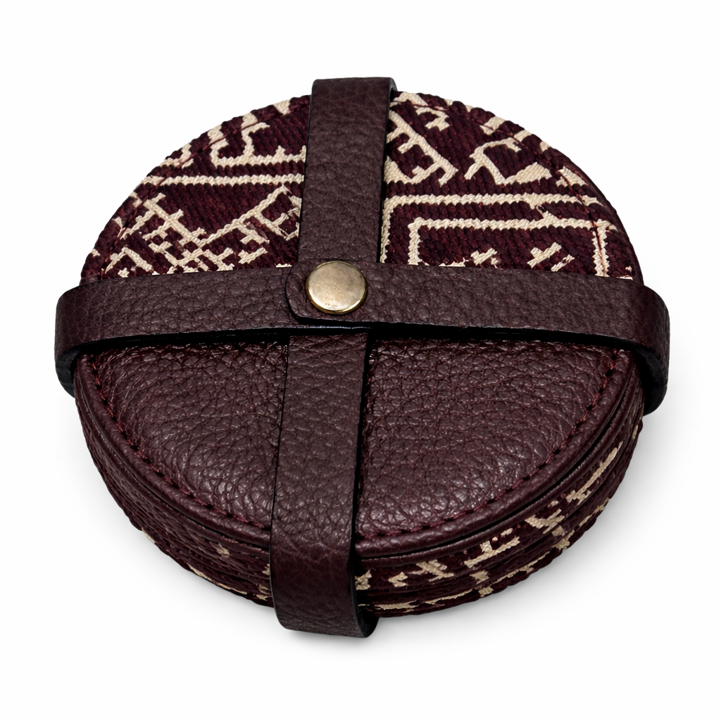 Pack de sous-tasses rondes burgundy en cuir et tissu Tarz à motifs écrus, maintenu par une attache en cuir.