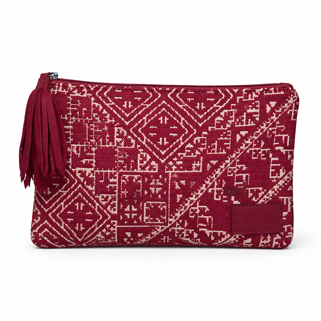 Petite pochette Tarz bordeau en tissu tissé marocain à motifs géométriques écrus, avec fermeture zippée et pompon noir décoratif.