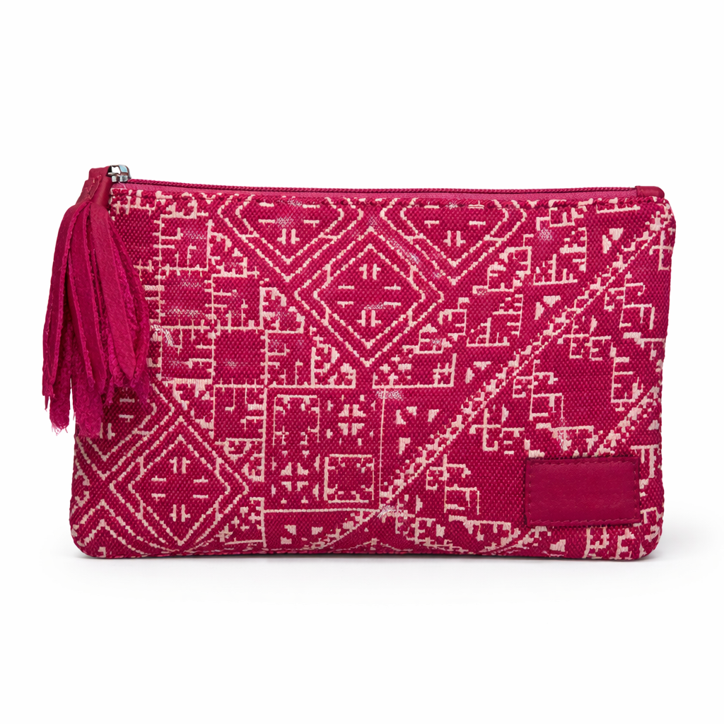 Petite pochette Tarz rose fushia en tissu tissé marocain à motifs géométriques écrus, avec fermeture zippée et pompon noir décoratif.