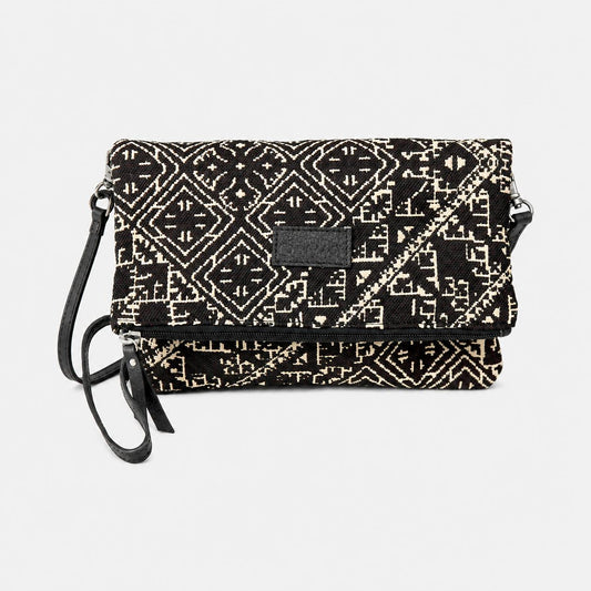 Sac bandoulière noir en tissu marocain tissé, ornée d’un motif géométrique inspiré des broderies traditionnelles de Fès, avec fermeture zippée et finitions en cuir, création exclusive Biyadi Collection fabriquée au Maroc.