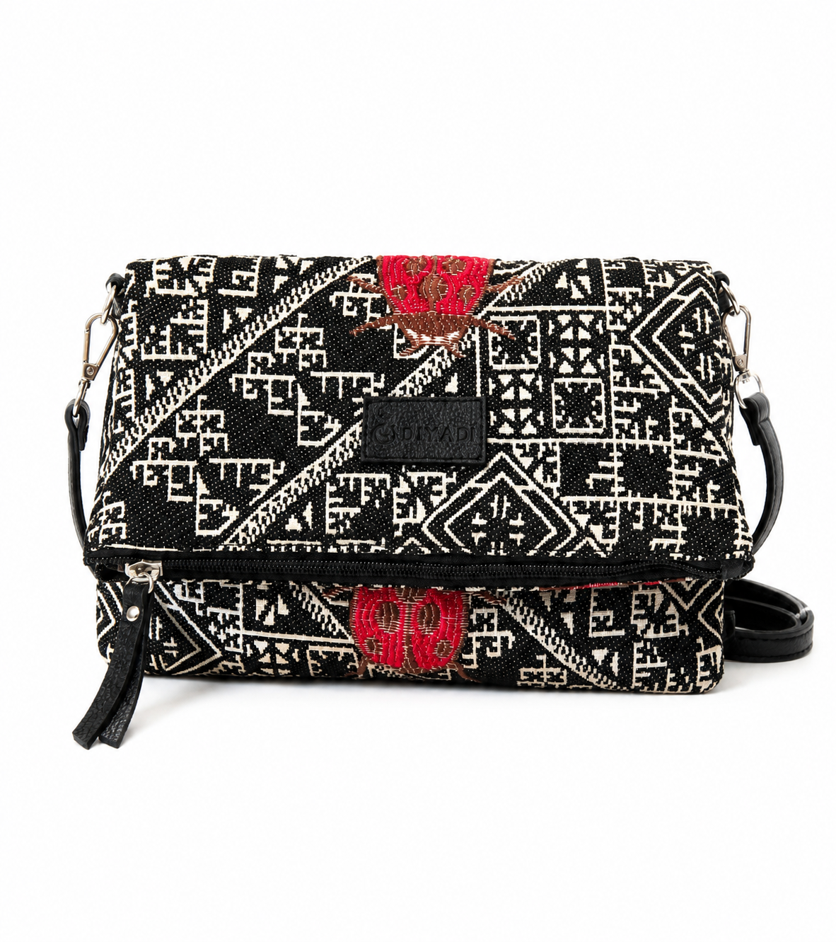 Sac bandoulière noire et rouge en tissu marocain tissé avec motif inspiré des broderies de Fes, fermeture zippée et finitions en cuir, création exclusive Biyadi Collection.