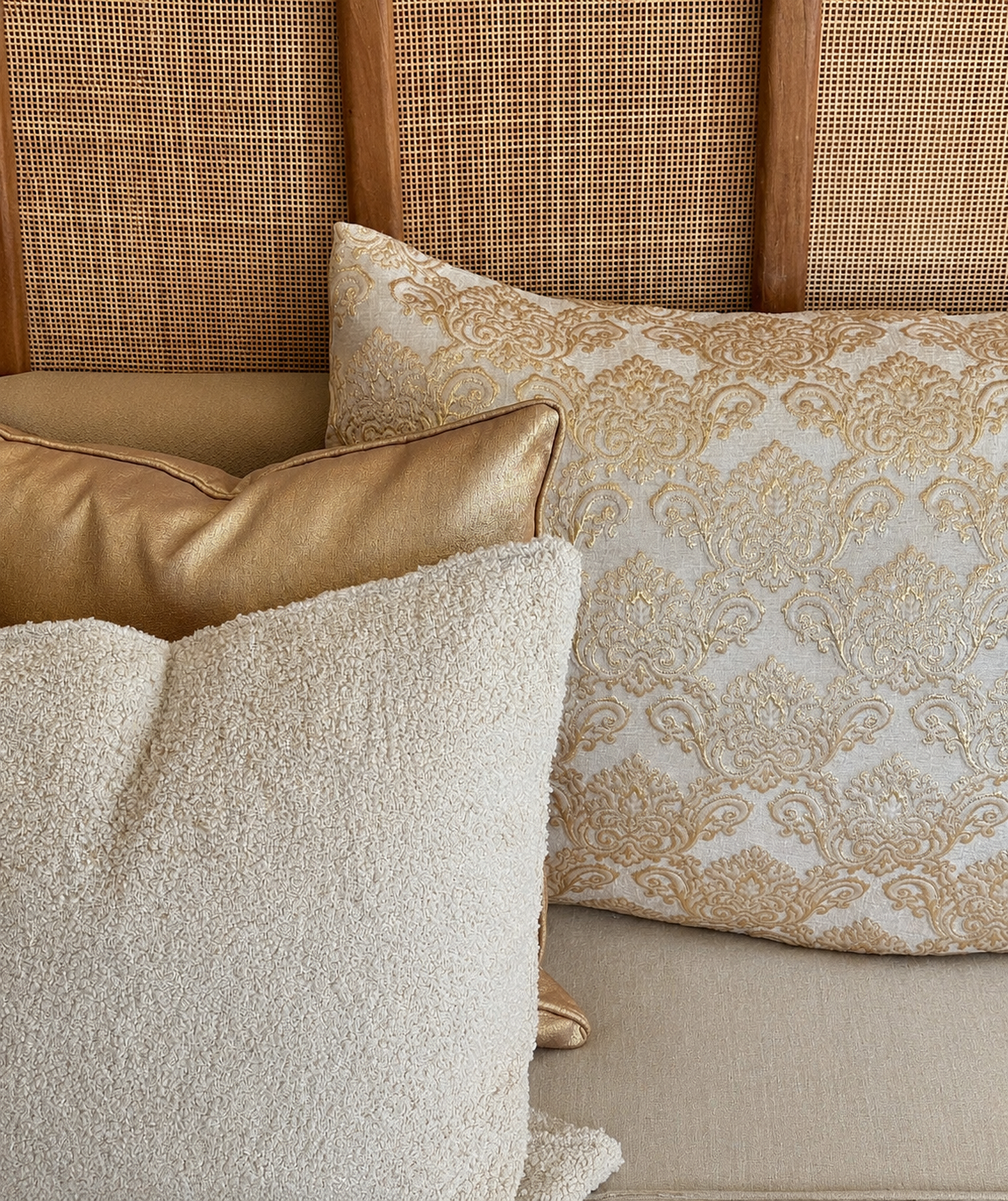 Composition de coussins décoratifs beige et doré avec coussin bouclette et motif damas raffiné, ambiance chic et chaleureuse pour salon moderne.