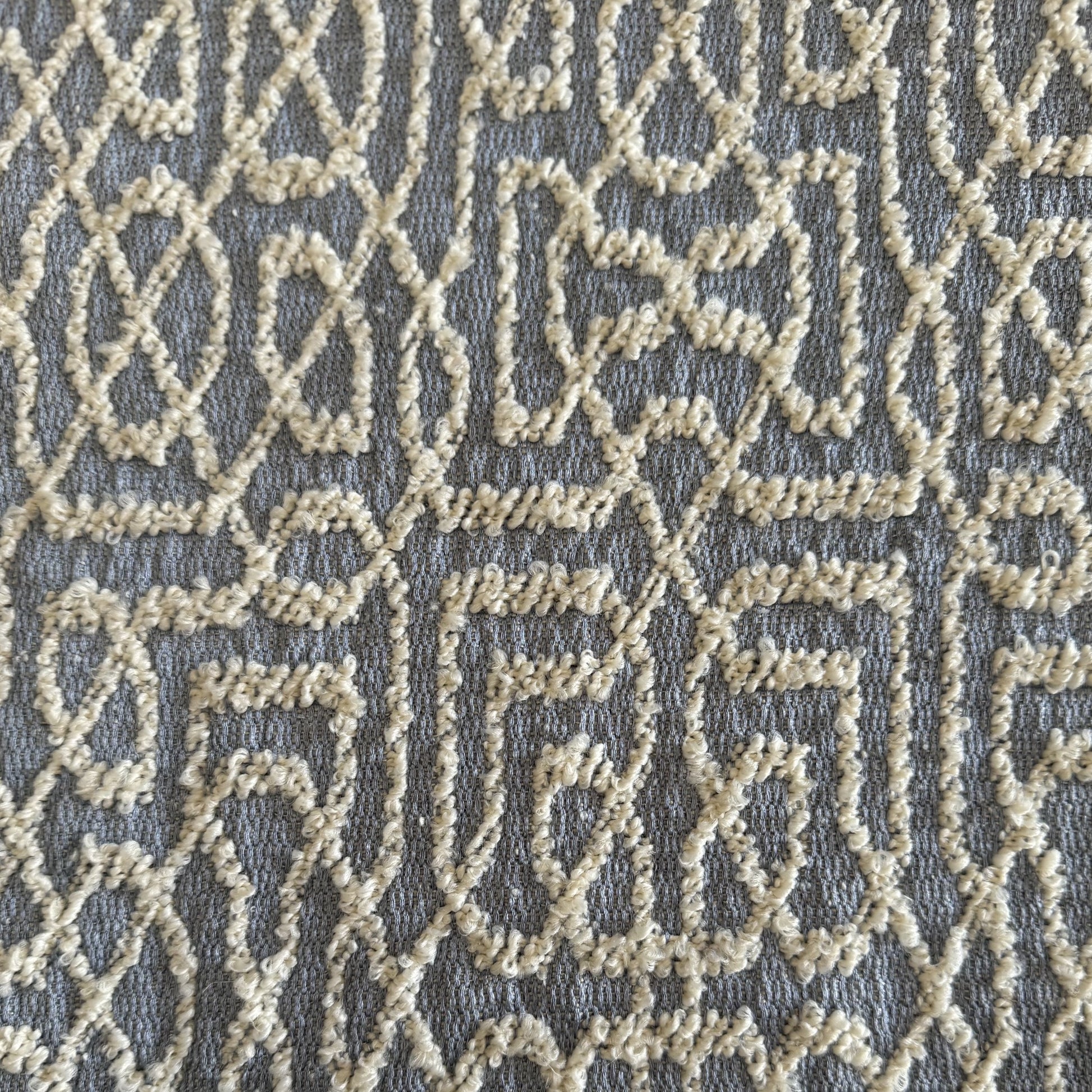 Tissu d’ameublement bouclette bleu ciel et écru à motif géométrique inspiré du moucharabieh marocain, avec relief texturé élégant pour coussins et décoration intérieure.