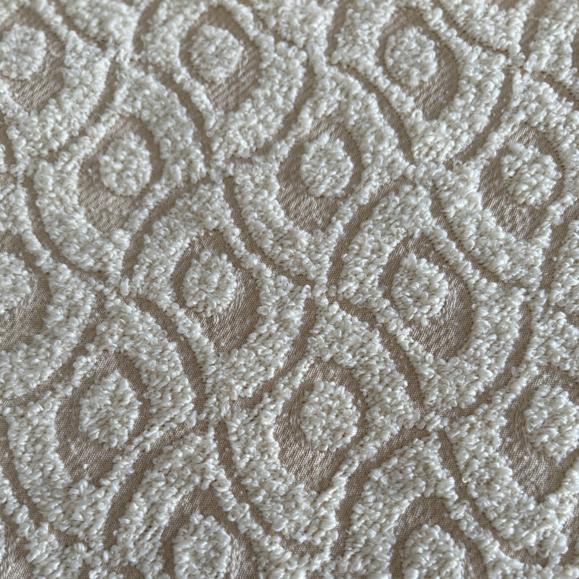 Gros plan sur un tissu bouclette blanc  à motif géométrique en relief, tissé au Maroc pour l'ameublement et la décoration intérieure.