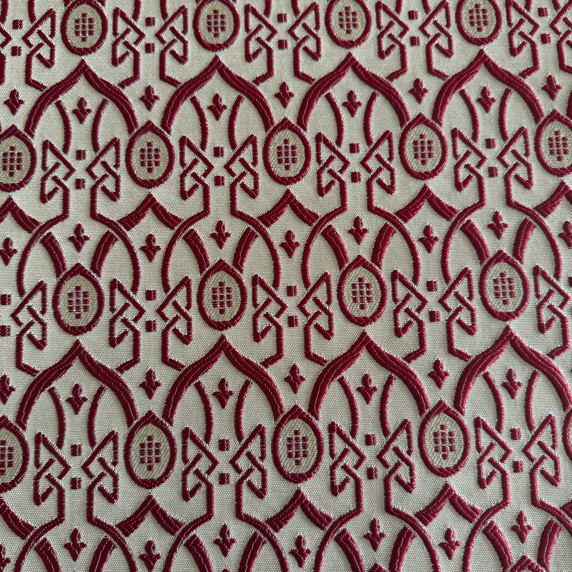 Tissu d’ameublement bordeaux à motif oriental en relief, effet brodé intégré au tissage, création exclusive tissée au Maroc par Biyadi Collection.

