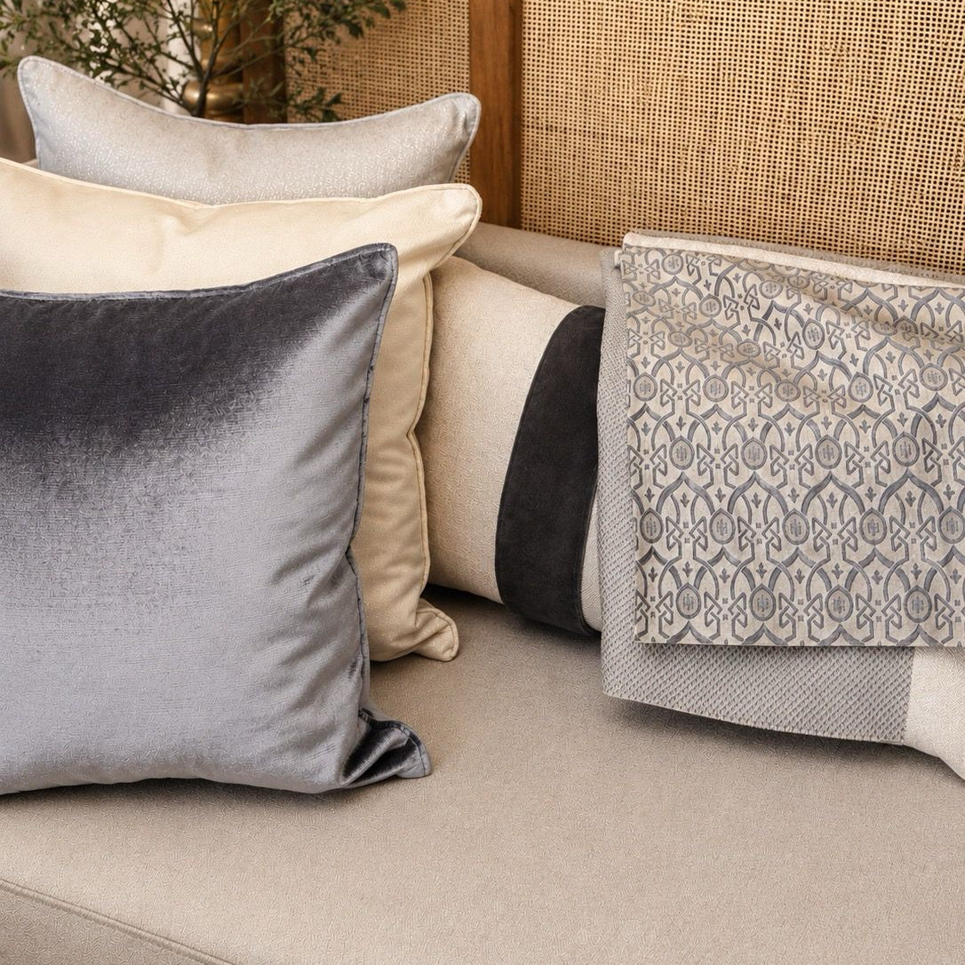 Tissu Élégance gris perle à motif oriental en relief, présenté dans une composition de salon raffinée, tissé au Maroc par Biyadi Collection.