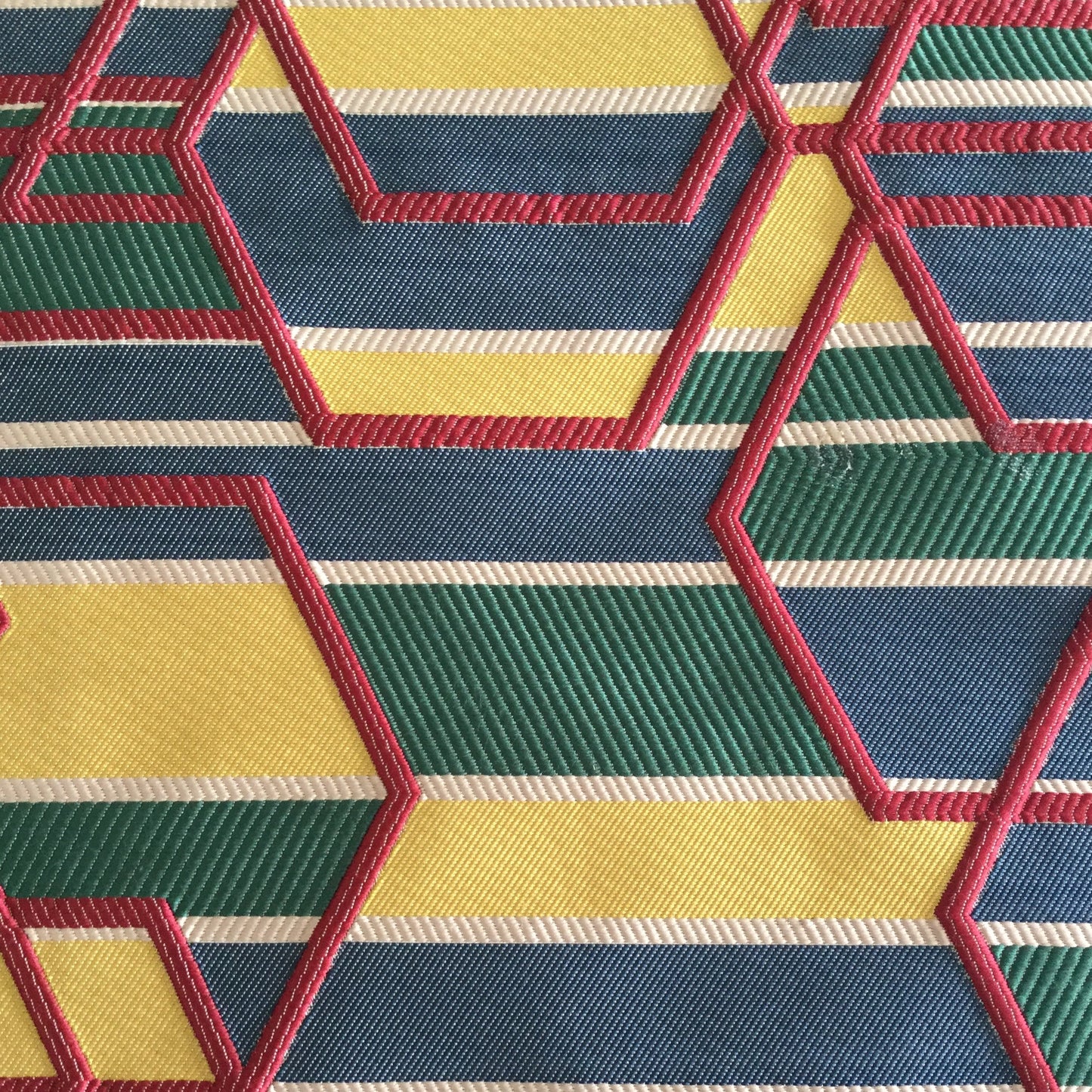 Tissu d'ameublement géométrique multicolore tissé en relief, avec motifs hexagonaux bleu, vert, jaune et rouge, fabriqué au Maroc pour décoration intérieure et coussins.