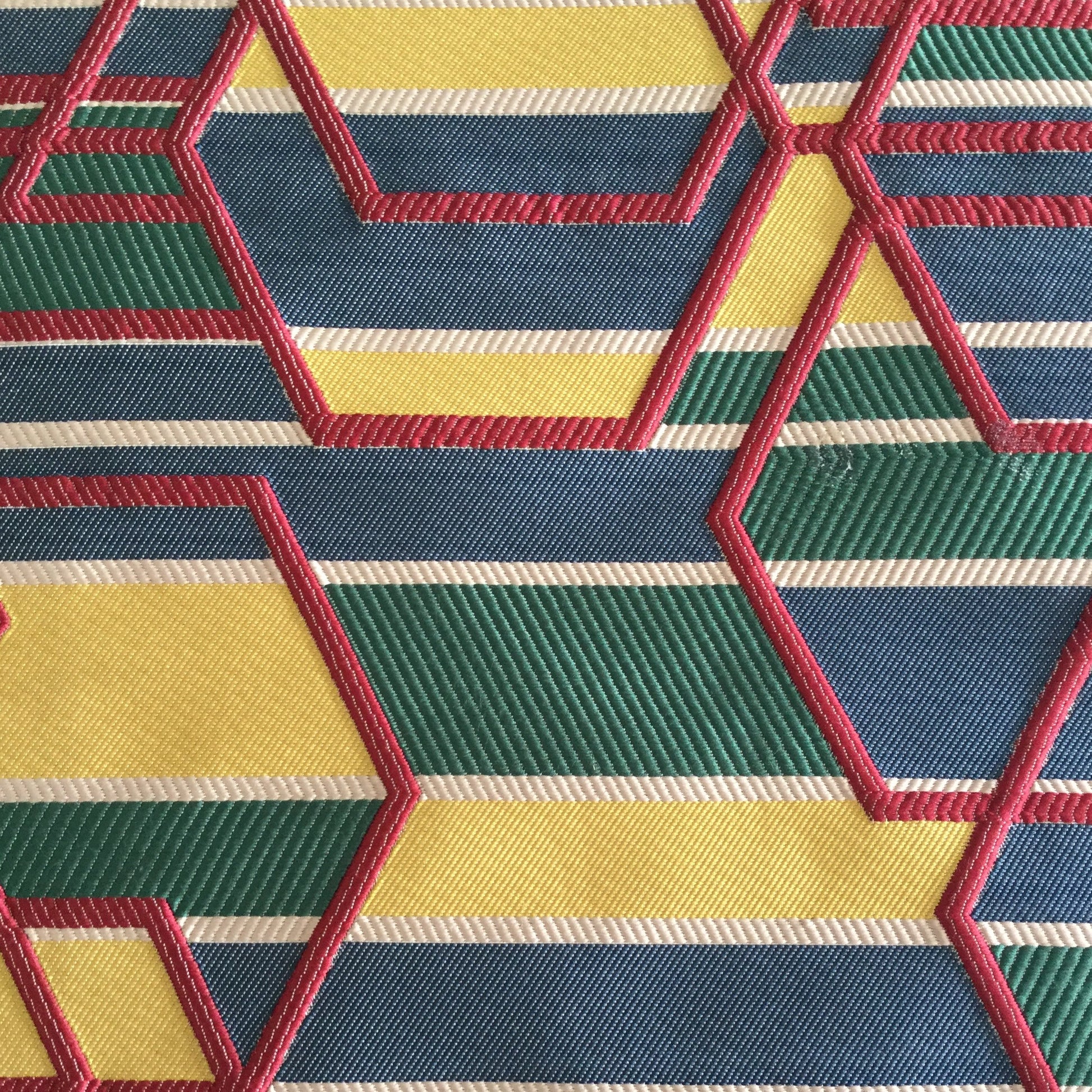 Tissu d'ameublement géométrique multicolore tissé en relief, avec motifs hexagonaux bleu, vert, jaune et rouge, fabriqué au Maroc pour décoration intérieure et coussins.