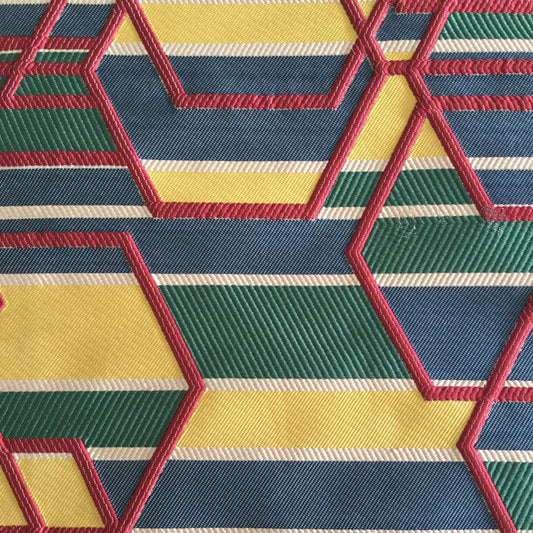 Tissu d'ameublement géométrique multicolore tissé en relief, avec motifs hexagonaux bleu, vert, jaune et rouge, fabriqué au Maroc pour décoration intérieure et coussins.
