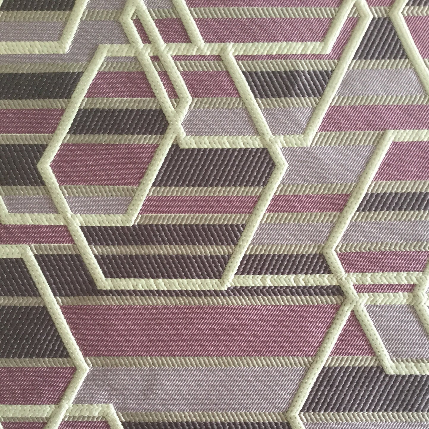 Tissu d'ameublement géométrique multicolore tissé en relief, avec motifs hexagonaux rose , blanc cassé , fabriqué au Maroc pour décoration intérieure et coussins.
