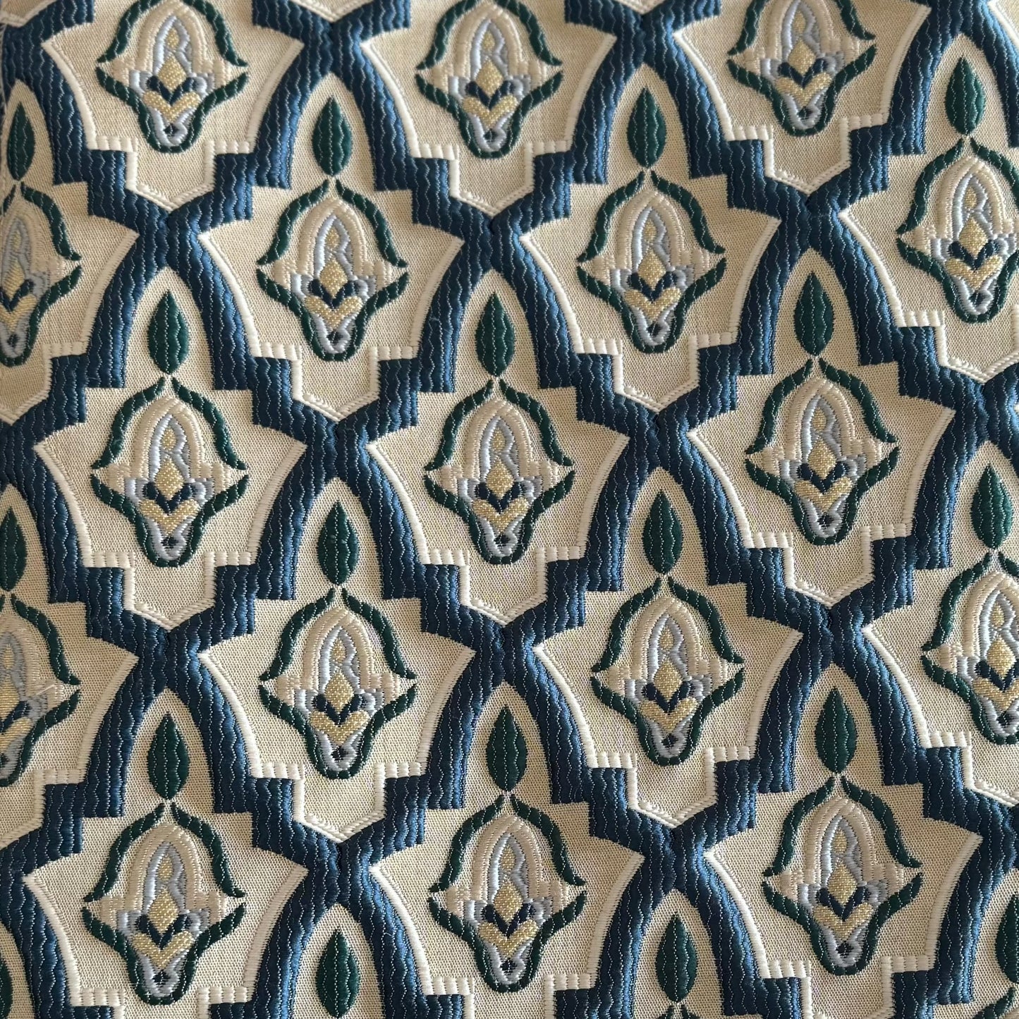 Tissu d'ameublement marocain à motif arabesque en relief( zellij) , dans des tons bleu pétrole, vert et ivoire, tissé au Maroc pour salons marocains, coussins et décoration intérieure.