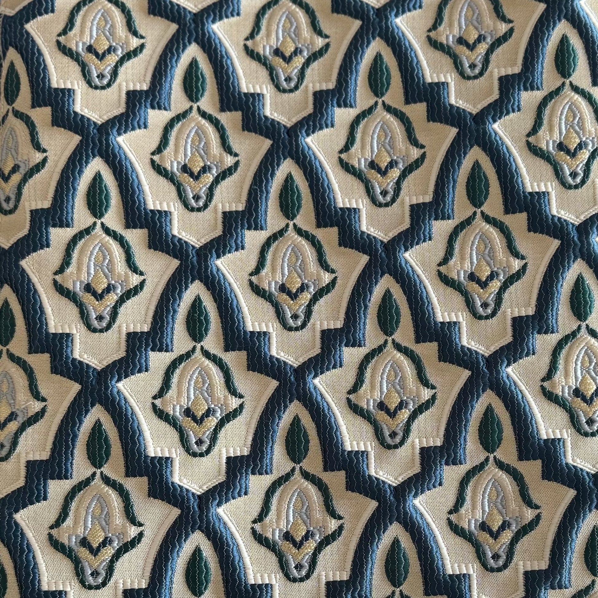 Tissu d'ameublement marocain à motif arabesque en relief( zellij) , dans des tons bleu pétrole, vert et ivoire, tissé au Maroc pour salons marocains, coussins et décoration intérieure.